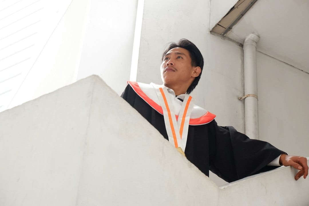 Graduate in academic gown at historic university campus