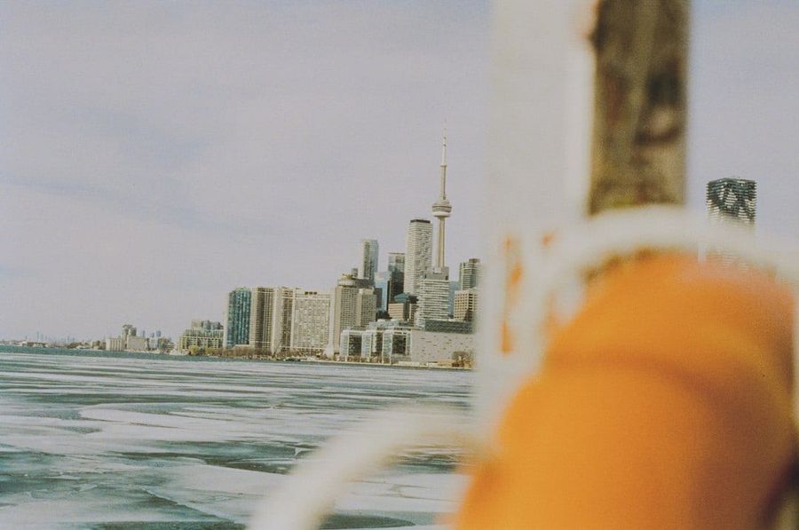 Couple with snowy Toronto skyline across frozen water