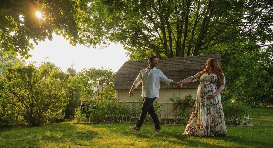 Happy couple holding hands in front of their new house